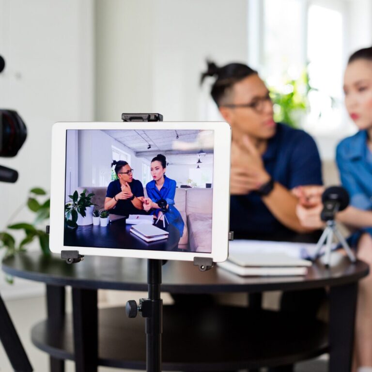 Two professionals recording video content, viewed from an ipad screen.